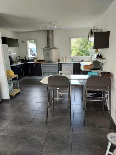 une cuisine avec une table et quelques chaises dans l'établissement VILLA FAMILIALE Bord de Mer, à Beg-Meil