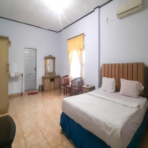 Postel nebo postele na pokoji v ubytování Hotel Niaga Bengkulu Mitra RedDoorz