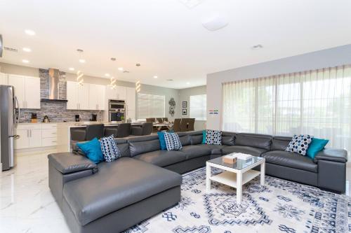 a living room with a couch and a kitchen at Top Dluxx Modern Home at Bella Vida Resort 4516 in Kissimmee