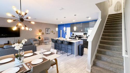 a living room and dining room with a staircase and a kitchen at Dream Townhouse with Splash Pool at Le Reve 4439 in Kissimmee