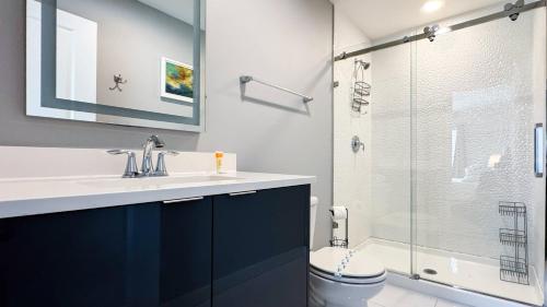 a bathroom with a sink and a glass shower at Dream Townhouse with Splash Pool at Le Reve 4439 in Kissimmee
