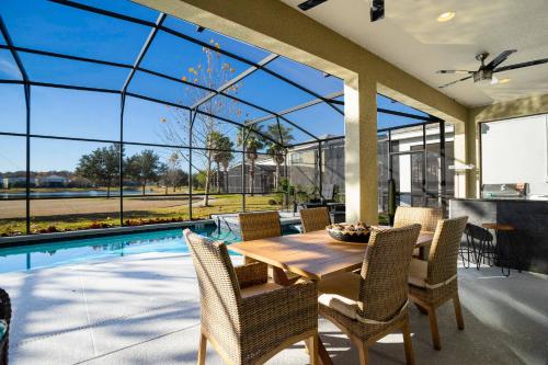 a dining room with a table and chairs and a pool at Top Dluxx Modern Home at Bella Vida Resort 4516 in Kissimmee