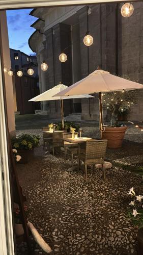 a group of tables with umbrellas in a courtyard at DANTES in Pieve di Teco