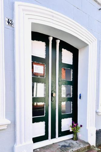 a front door of a house with a green door at Apartments-am-Wellenreiter-Kuestenstudio in Tating