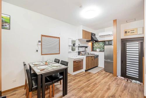 a kitchen with a table and chairs in a room at Tomo house in Tokyo