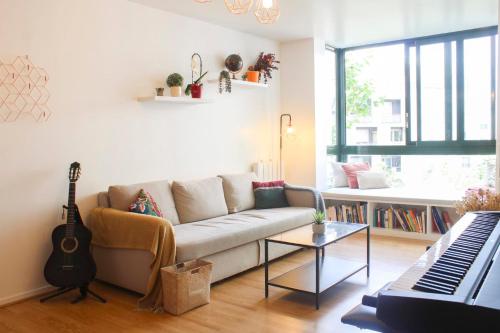 - un salon avec un canapé et un clavier dans l'établissement 1 bedroom apartment with garden, à Asnières-sur-Seine