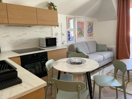 een keuken en woonkamer met een tafel en een bank bij New fully equiped appartment with parking in Saint-Mandé