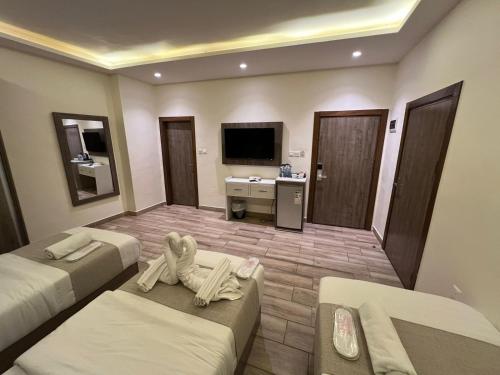 a hotel room with two beds and a tv at Sky Hotel in Aqaba