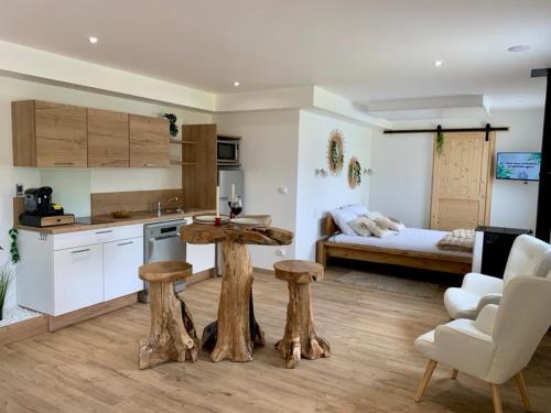 - une cuisine avec une table et deux tabourets dans une pièce dans l'établissement Les Nids Guérandais - Loverooms, à Guérande