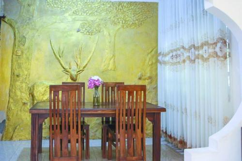 a dining room with a table with chairs and a painting at Lakmali Homestay in Watagederamulla