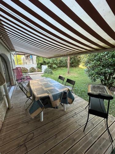 un patio avec une table et des chaises sur une terrasse dans l'établissement Charmant t2 dans une belle villa avec sa grande piscine, à Brive-la-Gaillarde