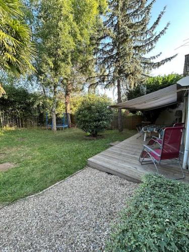 une terrasse en bois avec une table et une chaise. dans l'établissement Charmant t2 dans une belle villa avec sa grande piscine, à Brive-la-Gaillarde