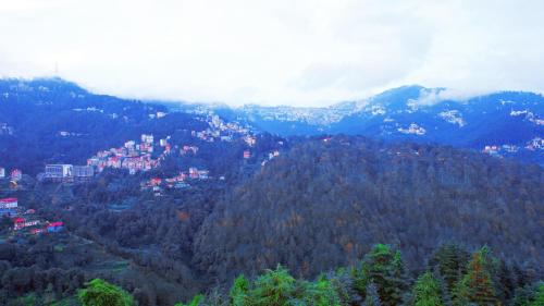 a view of a mountain with a town on top at Shimla Hills Apartments 2BHK in Shimla