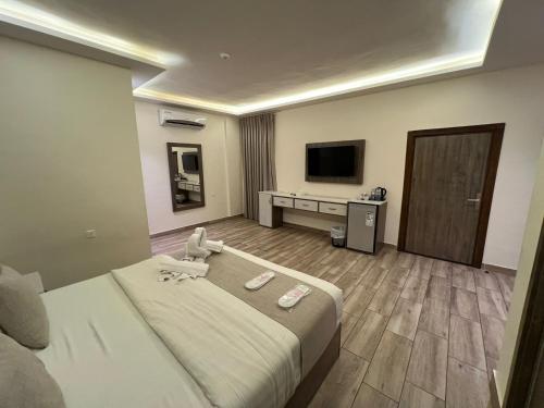 a hotel room with a bed and a flat screen tv at Sky Hotel in Aqaba
