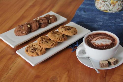 a plate of cookies and a cup of coffee at Sriracha Avenue Serviced Apartment in Si Racha
