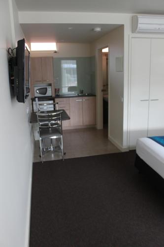 a hotel room with a kitchen and a bedroom at Mansfield Motel in Mansfield