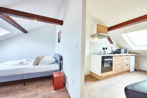une petite chambre avec un lit et une cuisine dans l'établissement RT 3 - Charmant F2 sous les combles 1-3 pers, à Mulhouse