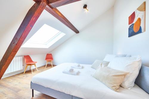 une chambre avec un lit et deux chaises dans l'établissement RT 3 - Charmant F2 sous les combles 1-3 pers, à Mulhouse