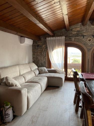a living room with a large couch and a window at Ca La Gràcia in Cabrianas