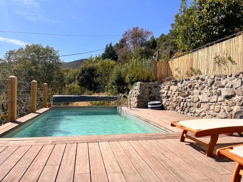 - une piscine sur une terrasse en bois avec une table dans l'établissement Maison Ardéchoise au calme avec vue et piscine, à Dunières-sur-Eyrieux