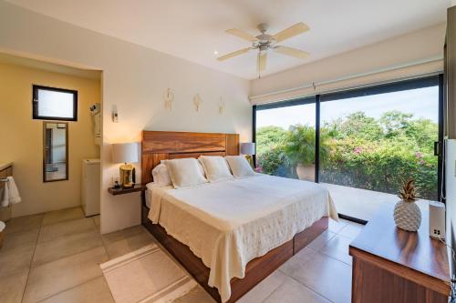 une chambre avec un grand lit et une grande fenêtre dans l'établissement 3033 - Agaves 103, à Santa Cruz Huatulco