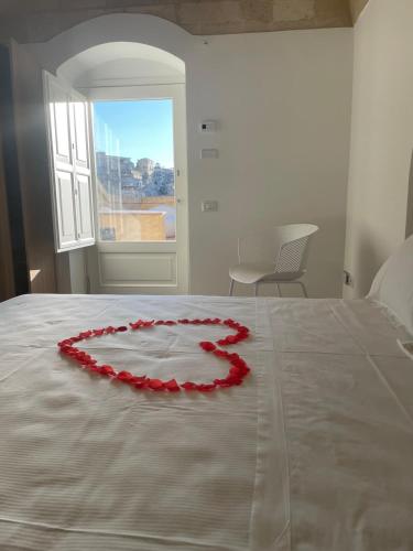 a bed with a red rose heart on it at Giardini di Luce in Matera