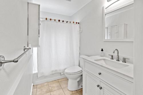 un bagno bianco con un water e un lavandino di D Cottage Lillian a Lillian