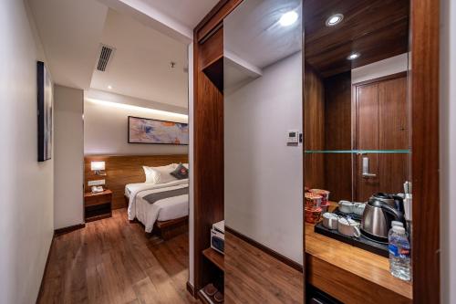 a hotel room with a bed and a door to a bedroom at Edoya Hotel Ben Thanh in Ho Chi Minh City