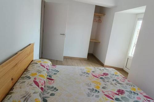 a bedroom with a bed with a floral bedspread at Casa Sáner in Rábade
