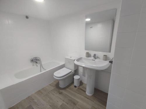 a white bathroom with a toilet and a sink at Casa Sáner in Rábade