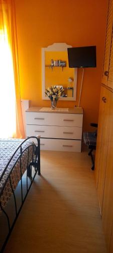 a bedroom with a bed and a dresser with a mirror at A casa di Aida in Ciampino