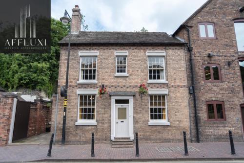 an old brick house with a white door at Ironbridge Riverside Hot Tub Retreat Sleeps 8 in Ironbridge