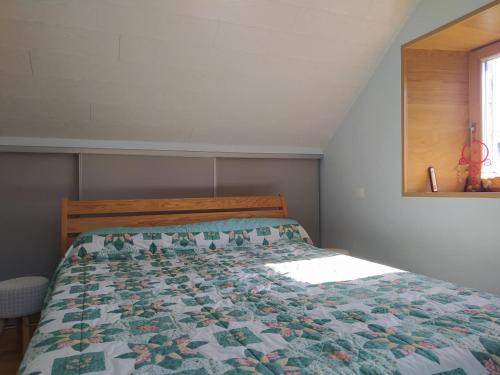 a bedroom with a bed with a quilt on it at Gite de 12 personnes a molines in Saint-Étienne-du-Valdonnez