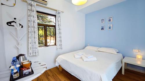 a white bedroom with a bed and a window at Cloud Tree Inn Boutique Guesthouse XiChong DaPeng ShenZhen 深圳大鹏西涌云树里民宿Yun Shu Li in Shenzhen