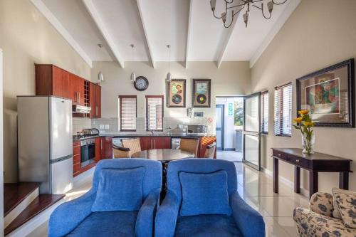 a kitchen with blue chairs and a table in it at 2 x Bedroom Loft apartment! in Knysna