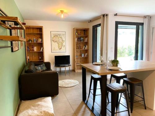 un salon avec une table et un bureau dans l'établissement Astoria - parking, vélos, jardin et terrasse, à Annecy