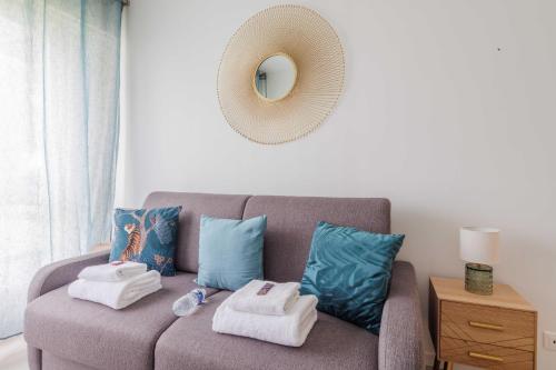 - un salon avec un canapé, des serviettes et un miroir dans l'établissement Wonderful studio - 2P - Neuilly-sur-Seine, à Neuilly-sur-Seine