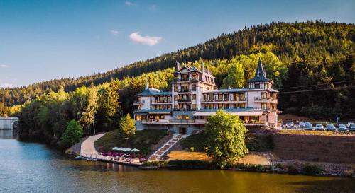 a large building on the side of a river at Retro Riverside Wellness Resort in Karlovy Vary