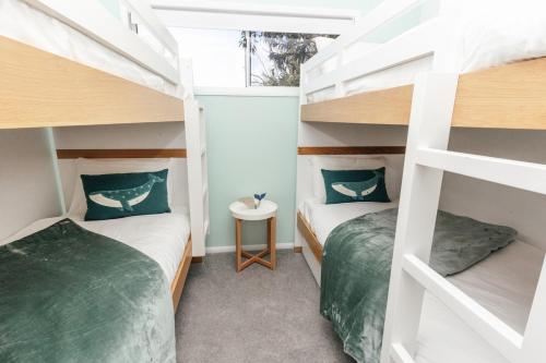 two beds in a room with two bunk beds at Breezy Beach House - Private Pool in Yaroomba