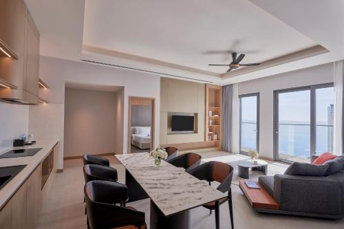 a kitchen and living room with a table and chairs at Adamas Boutique Hotel Nha Trang in Nha Trang