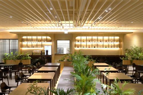 a restaurant with tables and chairs and plants at Phoenix Resort Pyeongchang in Pyeongchang 