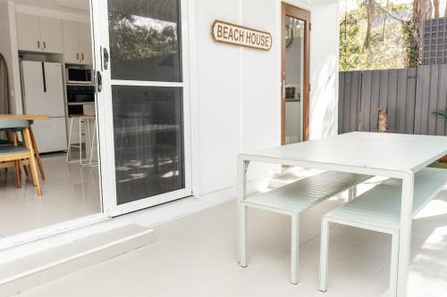 a white table and chairs in front of a kitchen at Breezy Beach House - Private Pool in Yaroomba
