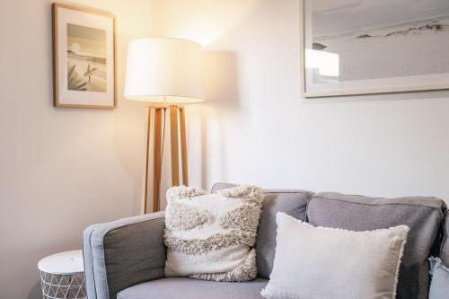 a living room with a couch and a lamp at Breezy Beach House - Private Pool in Yaroomba