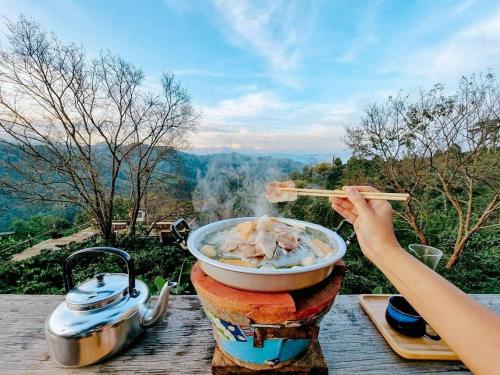 a person is eating a bowl of food with chopsticks at Ma Family Coffee Farm ไร่กาแฟครอบครัวมะ in Ban Huai Pong Nam Ron