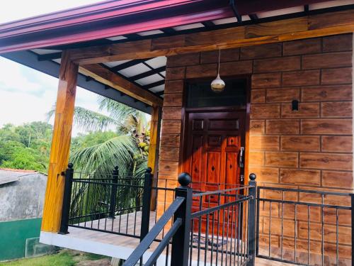 a wooden house with a wooden door and a balcony at Villa 42 in Ahungalla