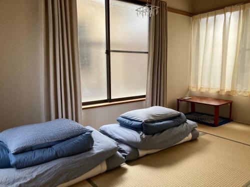 東京にあるWest Kamata 5 西蒲本家の窓付きの客室のベッド1台に枕2つ