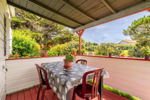 une table et des chaises sur une terrasse avec un toit dans l'établissement Chalet face mer Pointe Saint Gildas, à Préfailles