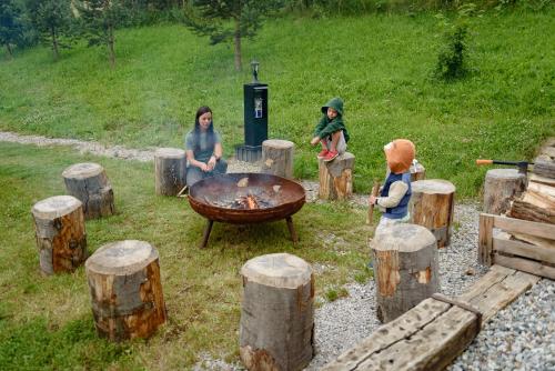 a group of people sitting around a grill with logs at Dom pri jazere, Bešeňová in Bešeňová