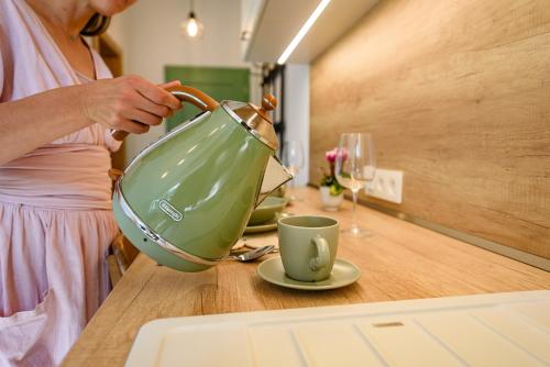 a woman is pouring coffee into a cup on a table at Dom pri jazere, Bešeňová in Bešeňová