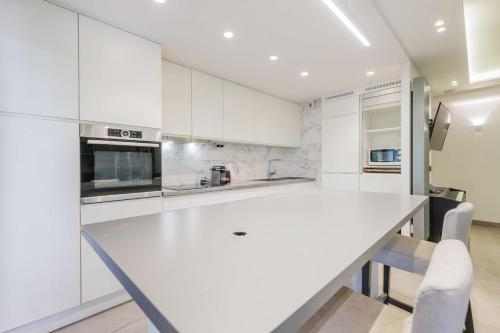 une cuisine blanche avec un grand comptoir blanc dans l'établissement Authentic apartment - 3BR-8P - La Villette, à Paris
